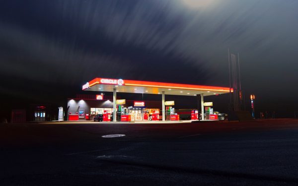 日韩电影画面：雨后的便利店门口，主角提着塑料袋站在路灯下，画面偏暖
