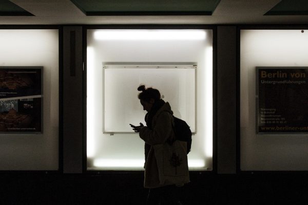 日韩电影在线观看人人 通勤地铁车厢里有人戴着耳机用手机看日韩电影，窗外灯光掠过画面，画面偏暖色